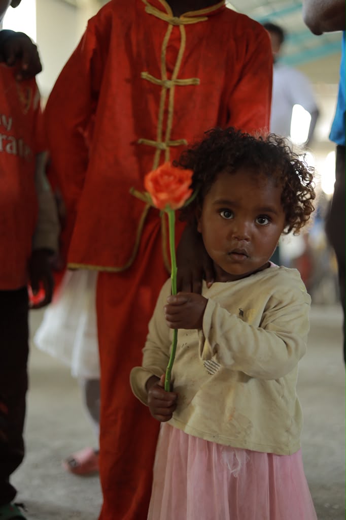 Young girl holding a flower at an event